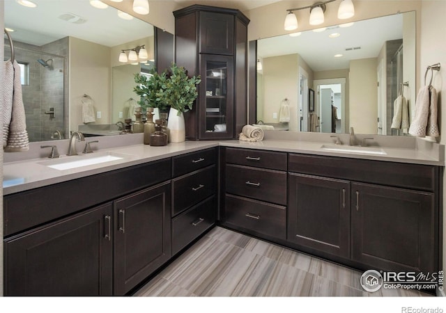 bathroom with vanity and tiled shower