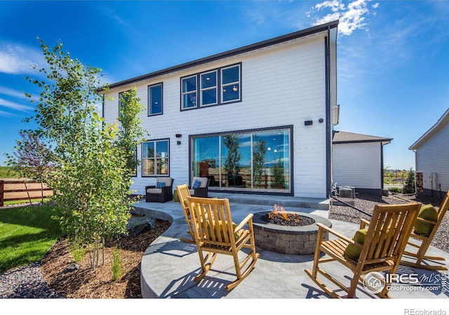 rear view of house with a patio area and an outdoor fire pit