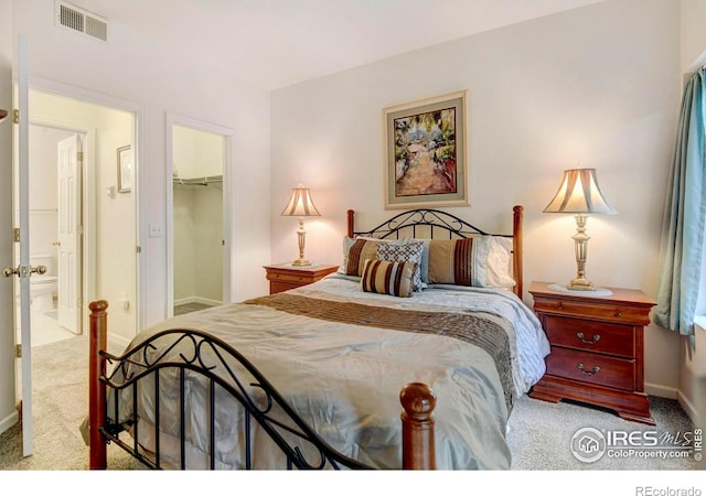 carpeted bedroom featuring a walk in closet and a closet