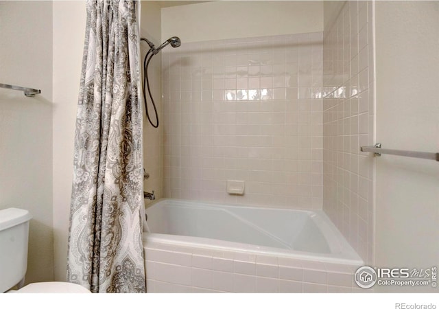 bathroom featuring shower / bath combo with shower curtain and toilet