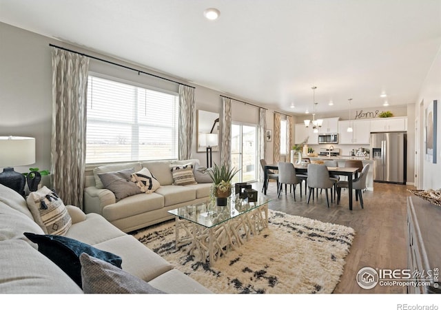 living room with a chandelier and light hardwood / wood-style flooring