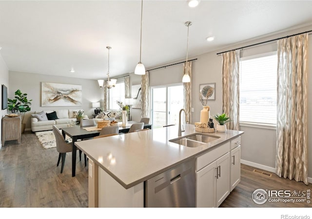 kitchen with white cabinetry, dishwasher, sink, hanging light fixtures, and a center island with sink