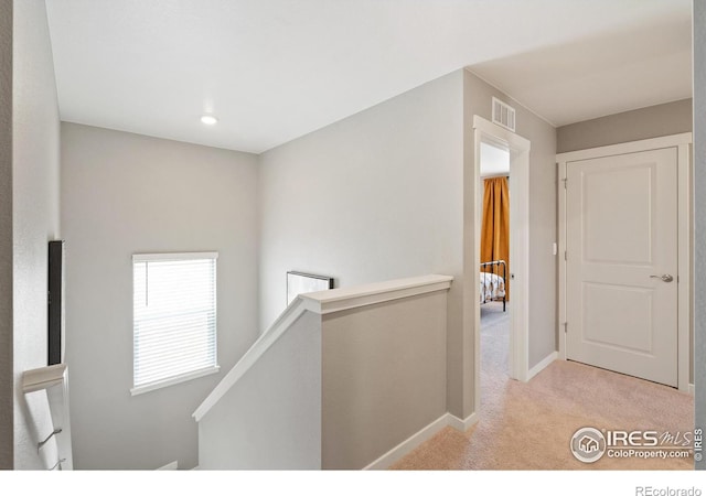 hallway with light colored carpet