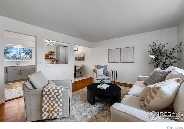 living room with light wood-type flooring and sink