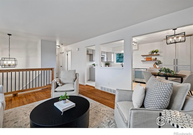 living room featuring an inviting chandelier and light hardwood / wood-style flooring