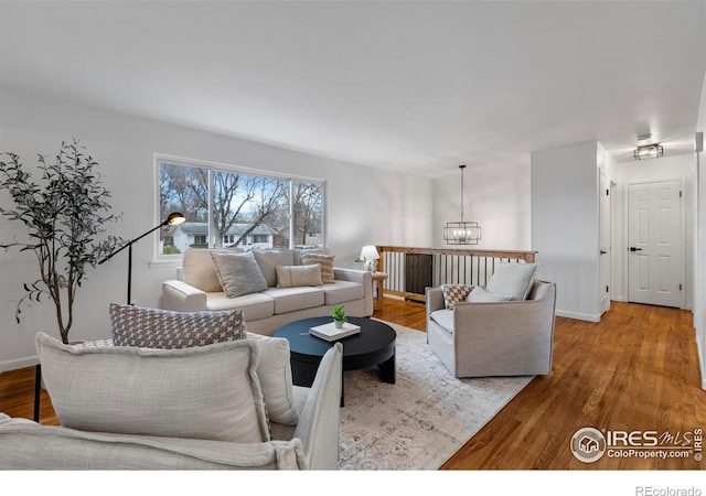 living room with a notable chandelier and light wood-type flooring