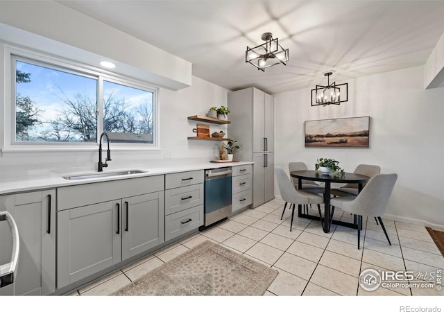 kitchen featuring gray cabinetry, dishwasher, sink, pendant lighting, and light tile patterned floors