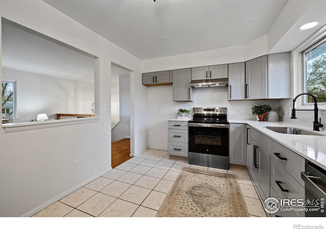 kitchen featuring light tile patterned floors, stainless steel appliances, gray cabinets, and sink