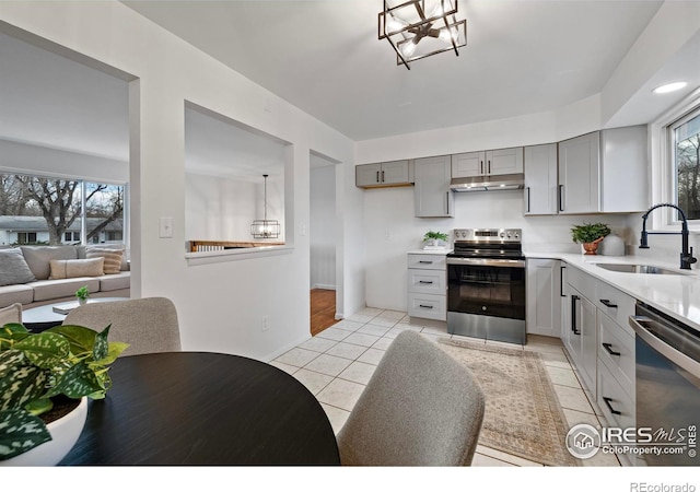 kitchen featuring gray cabinetry, pendant lighting, sink, light tile patterned floors, and appliances with stainless steel finishes