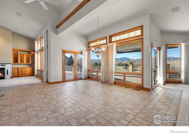 entryway featuring a mountain view, ceiling fan with notable chandelier, high vaulted ceiling, and french doors