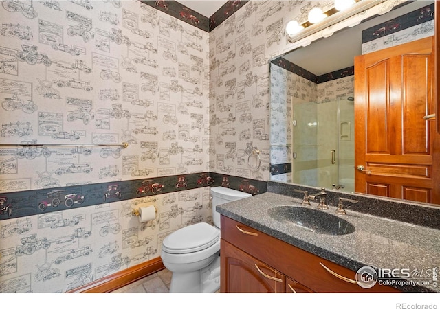 bathroom featuring vanity, toilet, and a shower with shower door