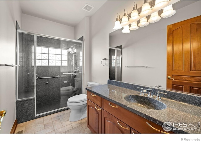 bathroom with vanity, toilet, and an enclosed shower