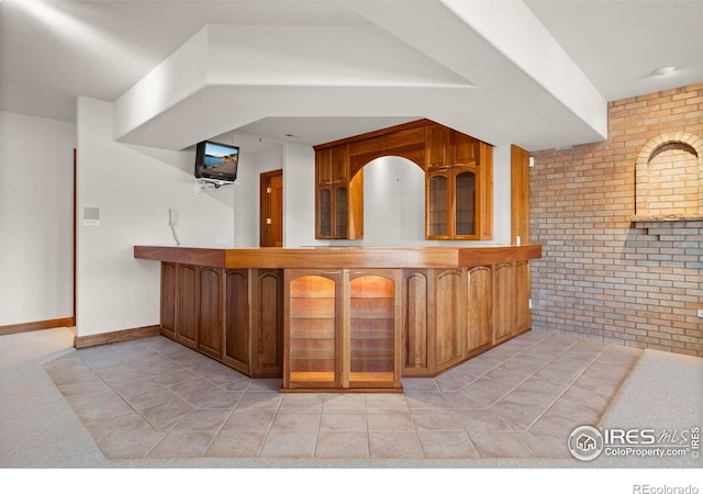 bar with light tile patterned floors and brick wall