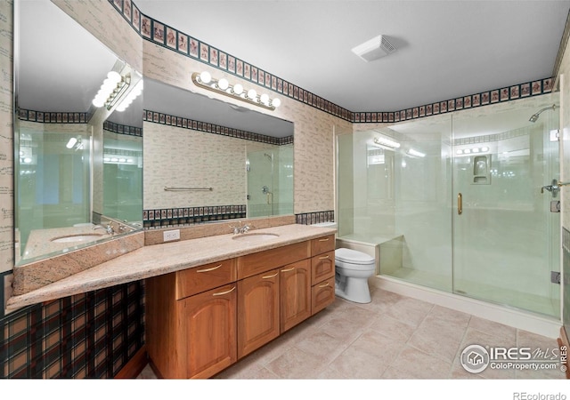 bathroom featuring tile patterned floors, a shower with door, vanity, and toilet