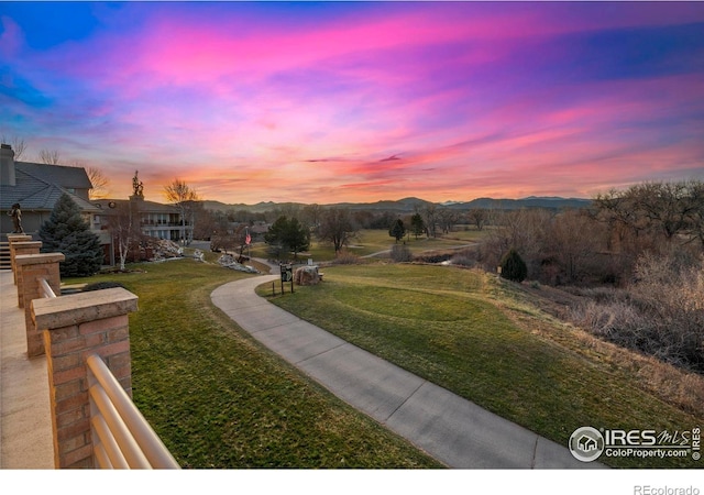 view of property's community with a mountain view and a yard