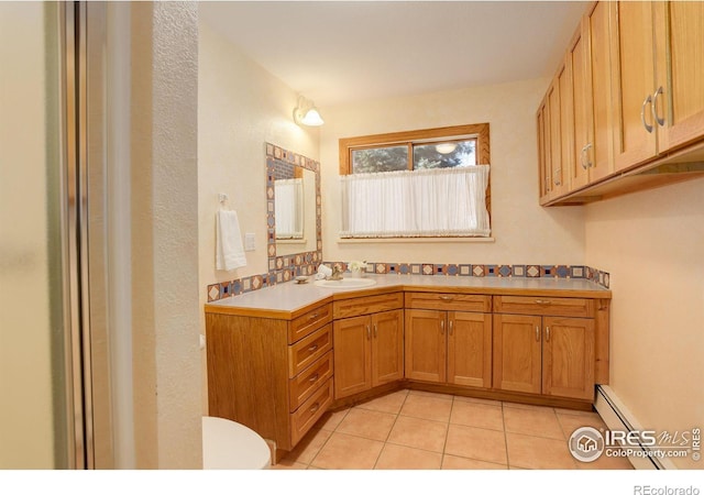 bathroom featuring tile patterned flooring, vanity, toilet, and a baseboard radiator