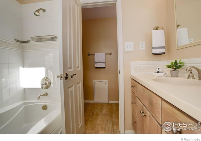 bathroom featuring vanity, wood-type flooring, and tiled shower / bath