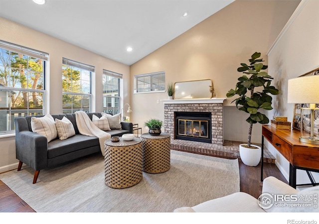 living room featuring a brick fireplace, hardwood / wood-style flooring, and vaulted ceiling