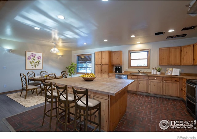 kitchen with a breakfast bar, sink, a center island, and stainless steel appliances