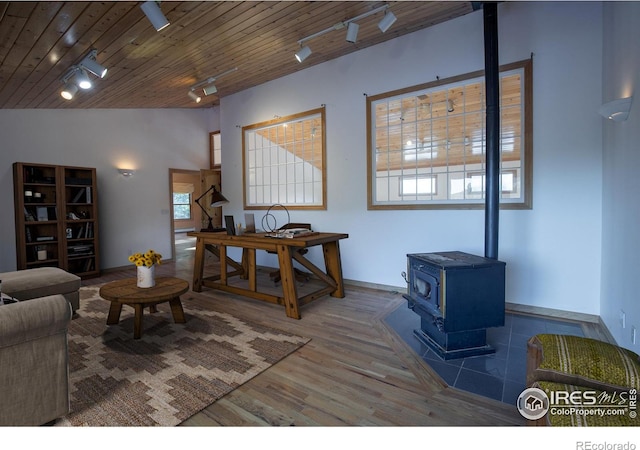 living room with rail lighting, vaulted ceiling, wooden ceiling, hardwood / wood-style floors, and a wood stove