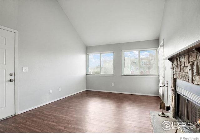 unfurnished living room featuring a fireplace, dark wood-type flooring, and vaulted ceiling