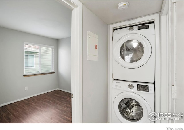 laundry room featuring dark hardwood / wood-style flooring, stacked washer and dryer, and electric panel