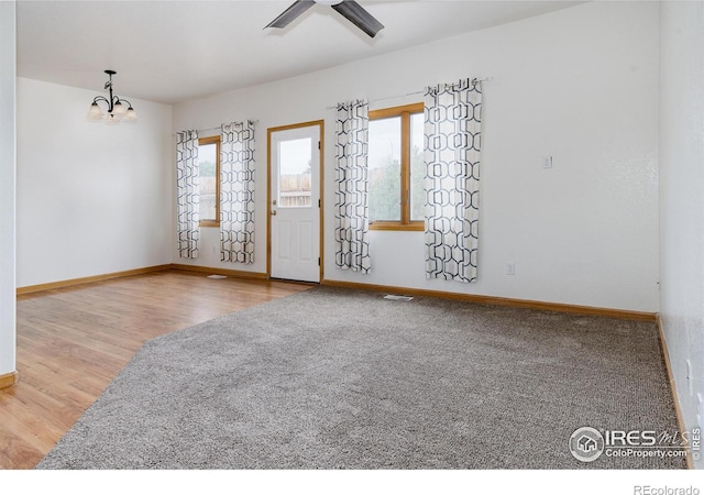 spare room featuring a notable chandelier and light wood-type flooring