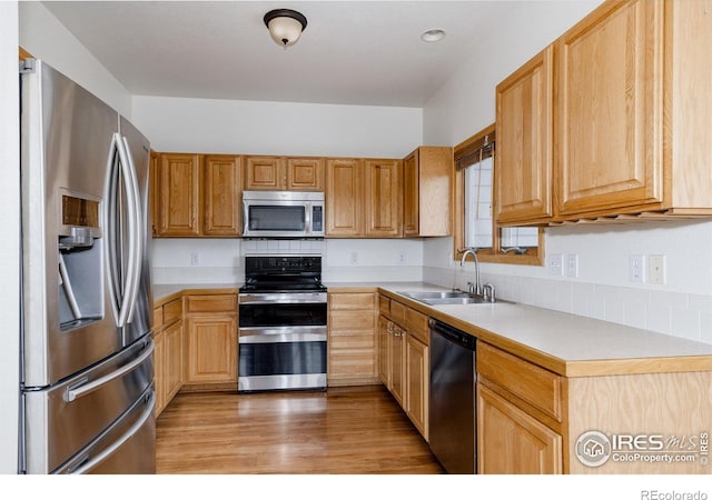 kitchen with sink, light wood-type flooring, and appliances with stainless steel finishes