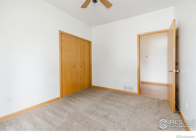 unfurnished bedroom featuring ceiling fan, a closet, and carpet