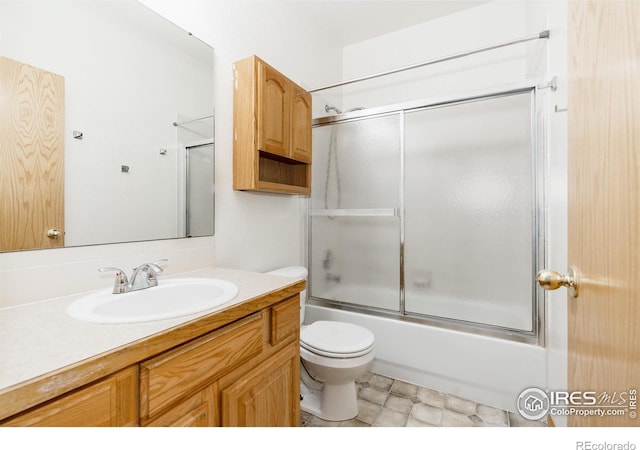 full bathroom featuring shower / bath combination with glass door, vanity, and toilet