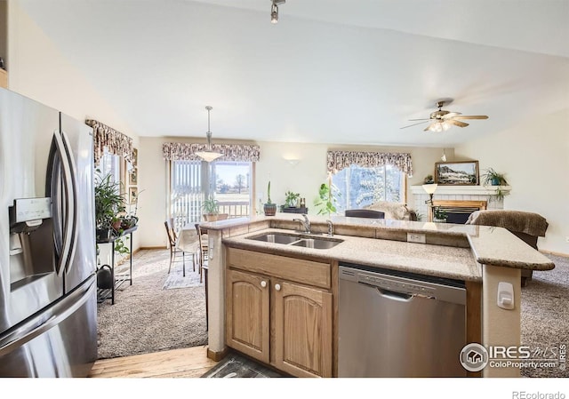 kitchen with pendant lighting, sink, ceiling fan, stainless steel appliances, and light wood-type flooring