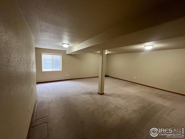 basement with light colored carpet and a textured ceiling