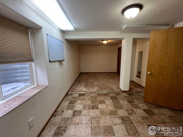 hall featuring a textured ceiling