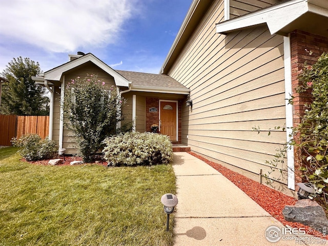 doorway to property with a lawn