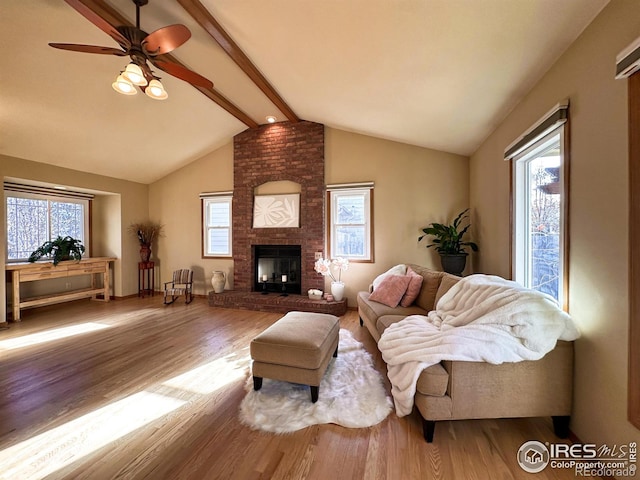 living room featuring vaulted ceiling with beams, hardwood / wood-style flooring, and a healthy amount of sunlight