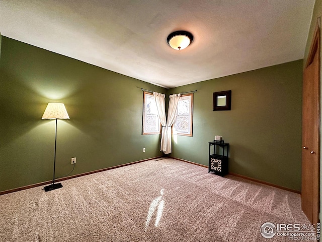 unfurnished room featuring carpet and a textured ceiling