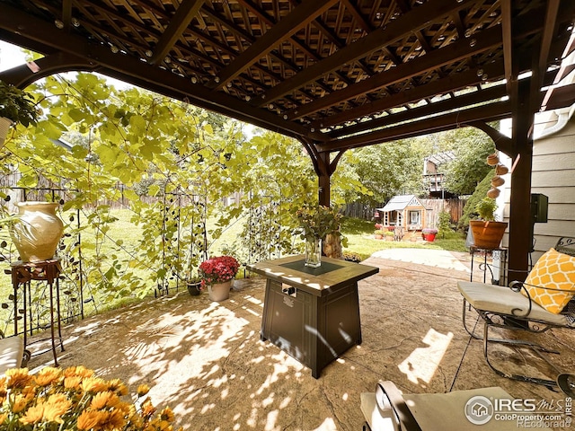 view of patio / terrace featuring a pergola and a storage unit