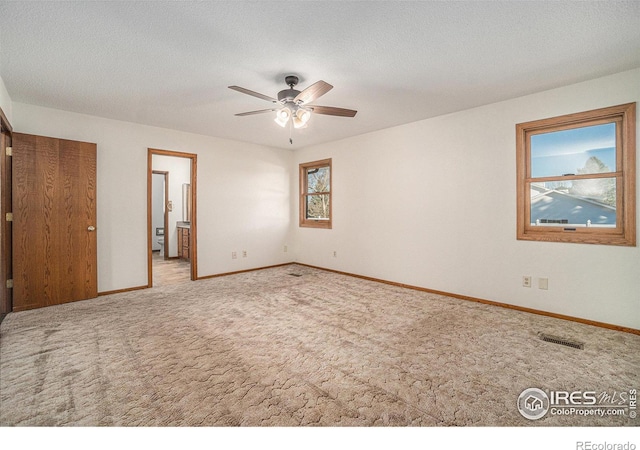 unfurnished room with ceiling fan, carpet floors, and a textured ceiling