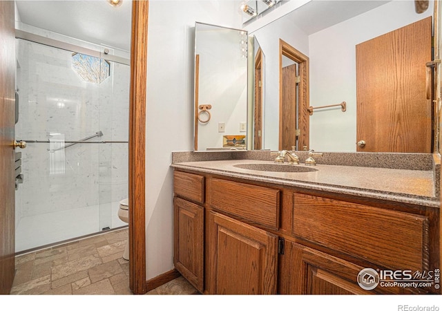 bathroom with vanity, toilet, and a shower with door