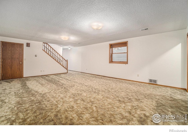 basement featuring carpet flooring and a textured ceiling