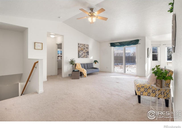 living room with carpet floors, ceiling fan, and vaulted ceiling