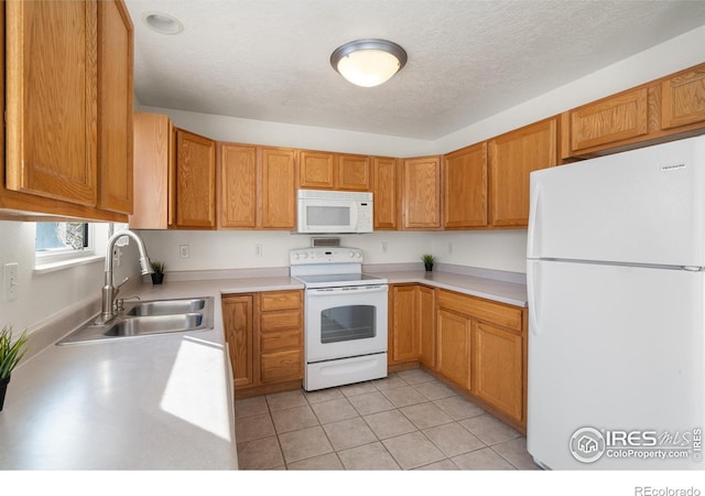 kitchen with white appliances, sink, and light tile patterned floors