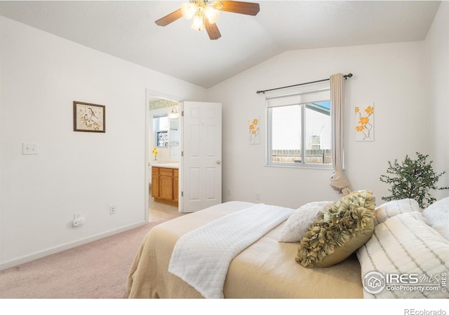 bedroom with lofted ceiling, ensuite bath, light colored carpet, and ceiling fan