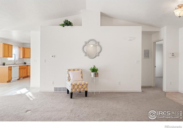 sitting room with light colored carpet, lofted ceiling, and sink