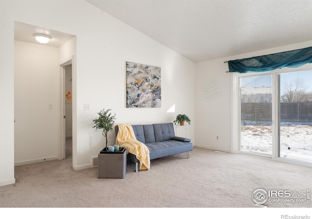 sitting room featuring vaulted ceiling and carpet