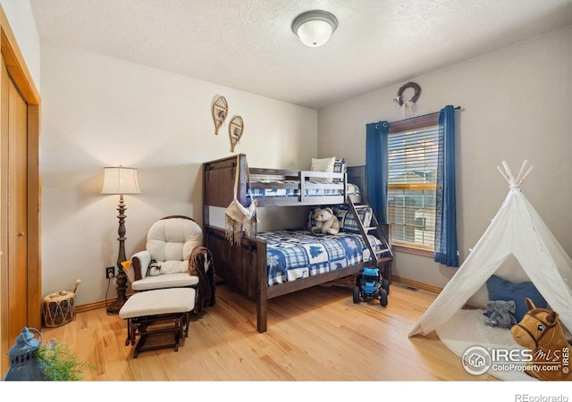 bedroom featuring hardwood / wood-style flooring and a textured ceiling