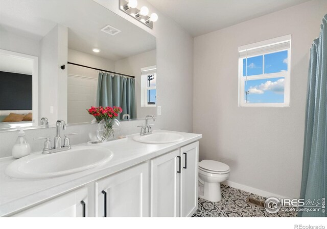 bathroom with vanity, tile patterned floors, and toilet