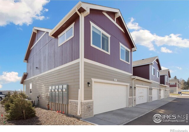 view of side of property with central AC unit and a garage