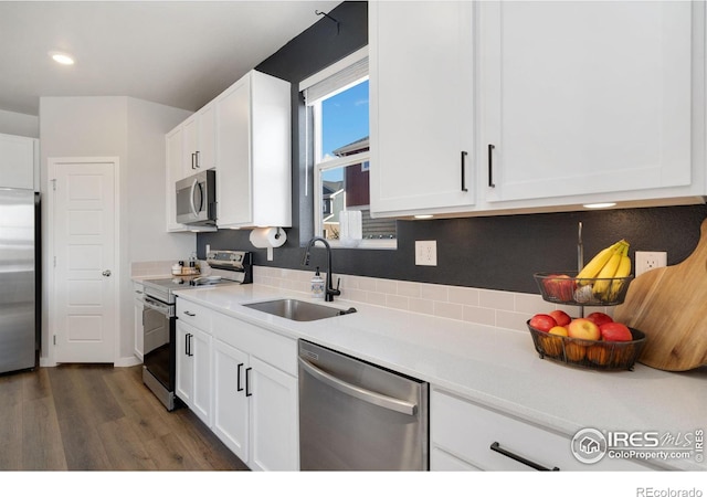 kitchen featuring stainless steel appliances, white cabinetry, sink, and dark hardwood / wood-style floors