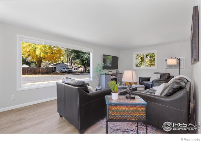 living room with light hardwood / wood-style floors and a wall mounted air conditioner